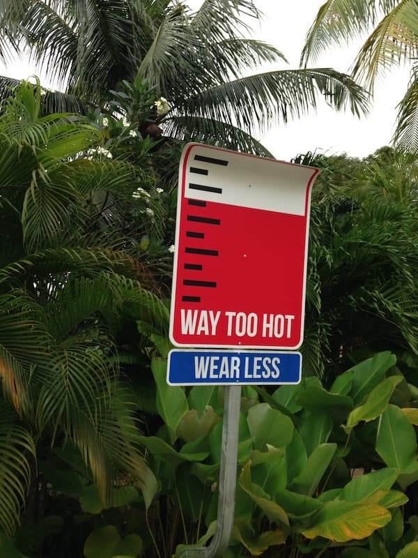 The street sign written 'way too hot, wear less